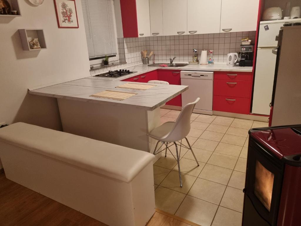 une cuisine avec des placards rouges et un comptoir blanc dans l'établissement Apartman Delnice Park Srna, à Delnice