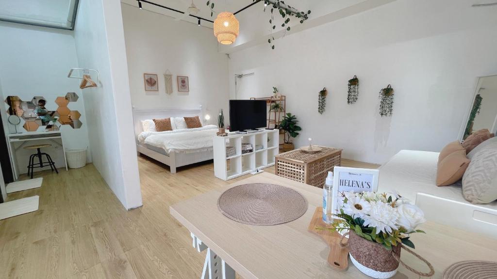 a living room with a couch and a table with flowers at Helena’s Studio Suite Gerik in Gerik