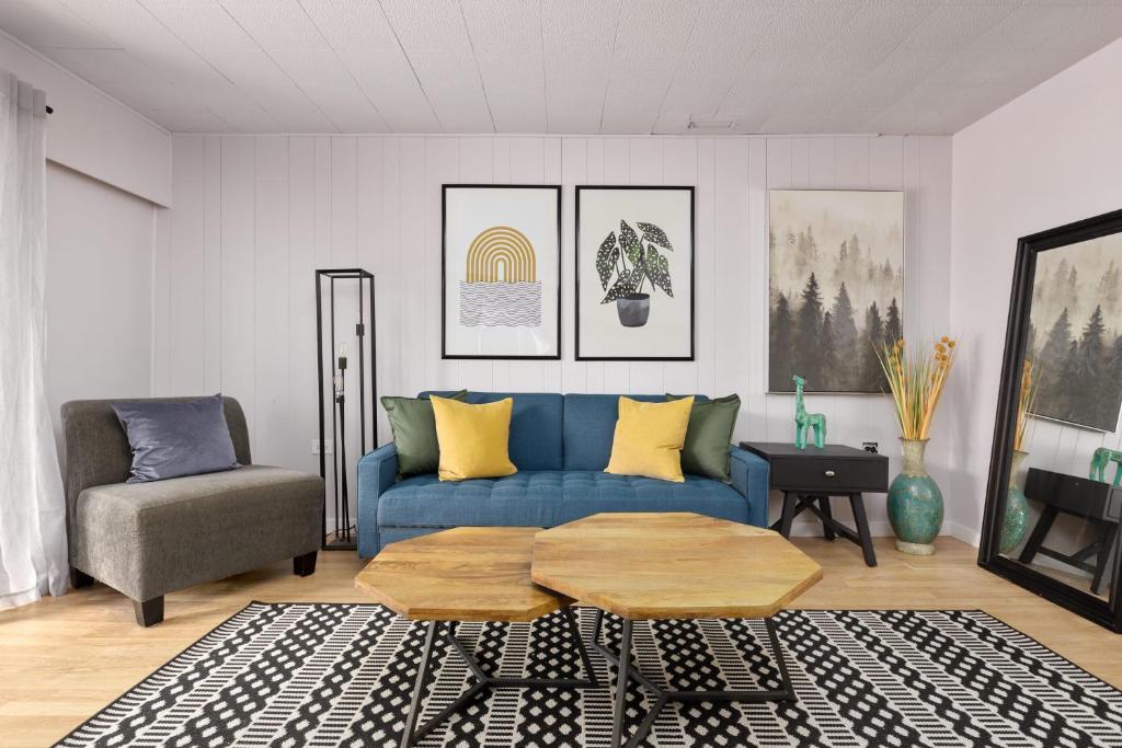 sala de estar con sofá azul y silla en Hot tub 2 BR beautiful seconary suite, en Burnaby
