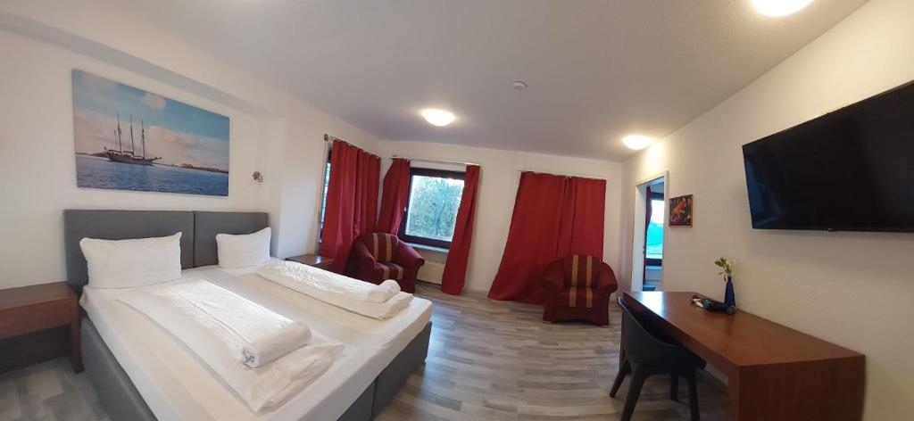 a bedroom with a bed and a desk and a television at City Centre Unterkunft in Itzehoe