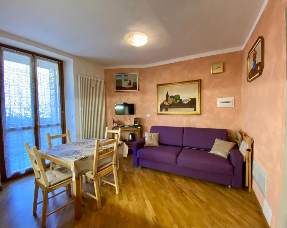 a living room with a purple couch and a table at SARA'S in Bardonecchia