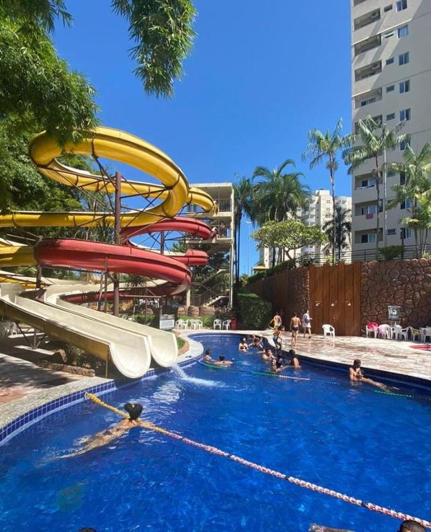 a swimming pool with a water slide at Suíte Grand Hotel Dolphin in Caldas Novas