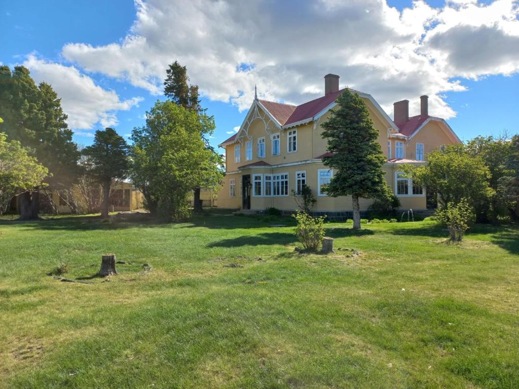 een groot geel huis met een grasveld bij Estancia Río Penitente in Villa Tehuelche 