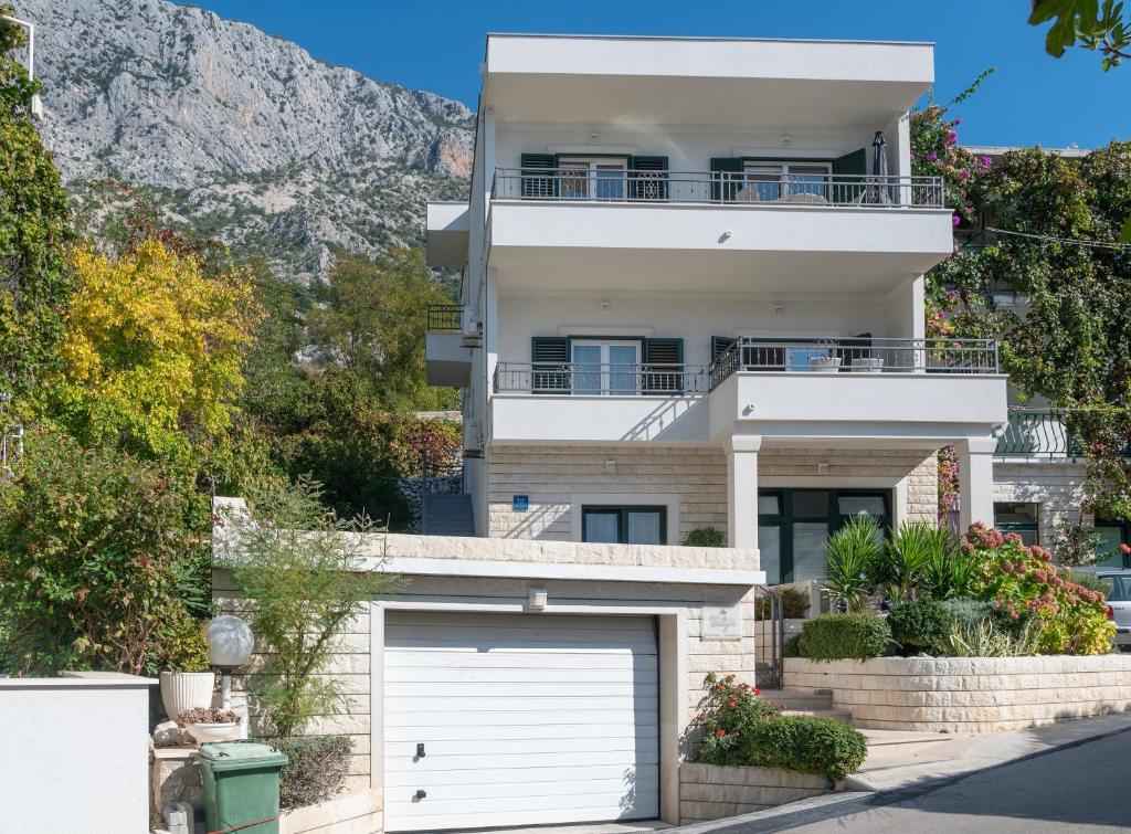 a large white house with a garage at Apartments Talija in Drasnice