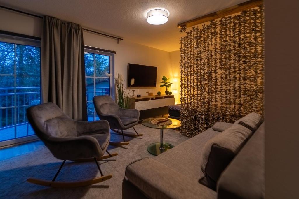 uma sala de estar com um sofá e cadeiras e uma televisão em Fewo Thermal Bad Saarow em Bad Saarow