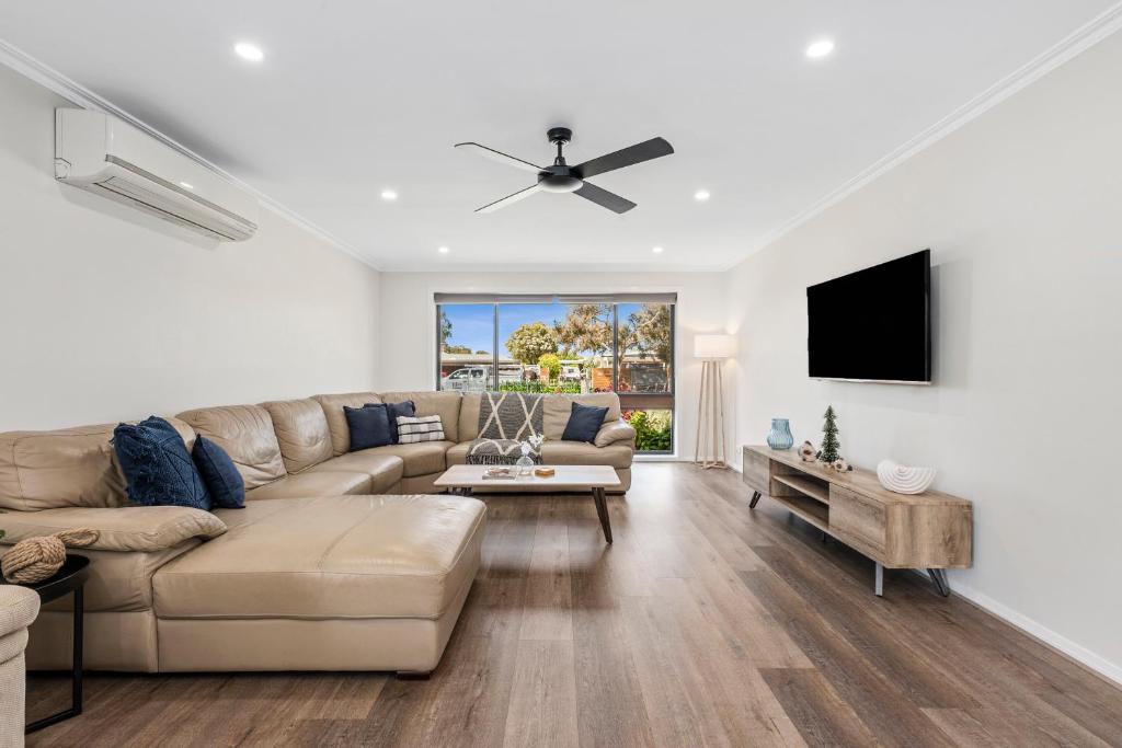 a living room with a couch and a flat screen tv at Tidal Waves on Lowe - Ocean Grove in Ocean Grove