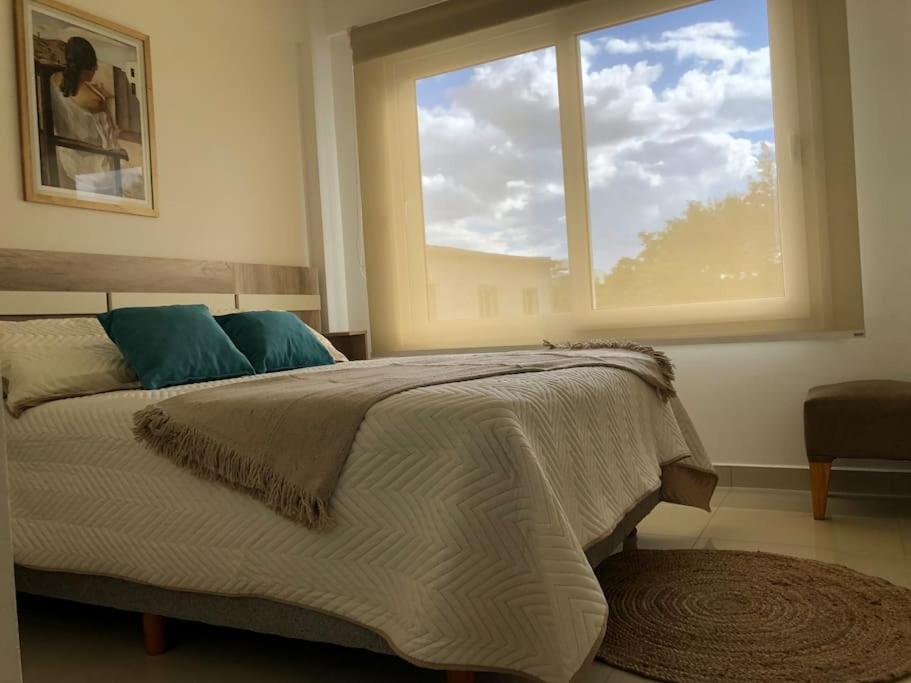 1 dormitorio con cama y ventana grande en Hermoso departamento céntrico con cochera en Tandil