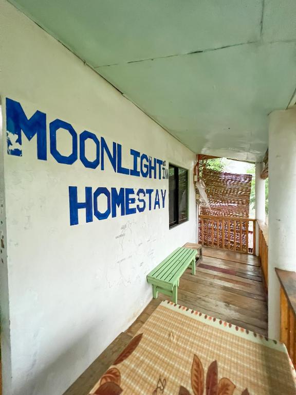 ein Zimmer mit einer grünen Bank und einem Schild an der Wand in der Unterkunft Moonlight's Inn in General Luna