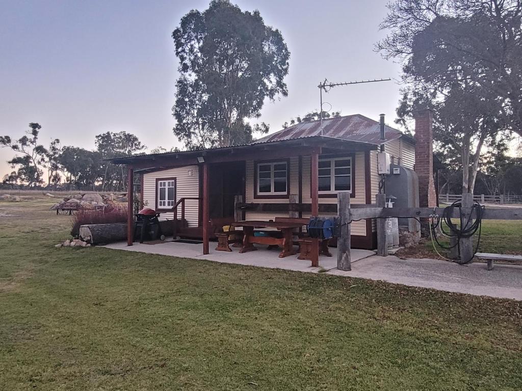 a small house with a picnic table in front of it at Spencer Lane Cottage & Granny Flat in Stanthorpe