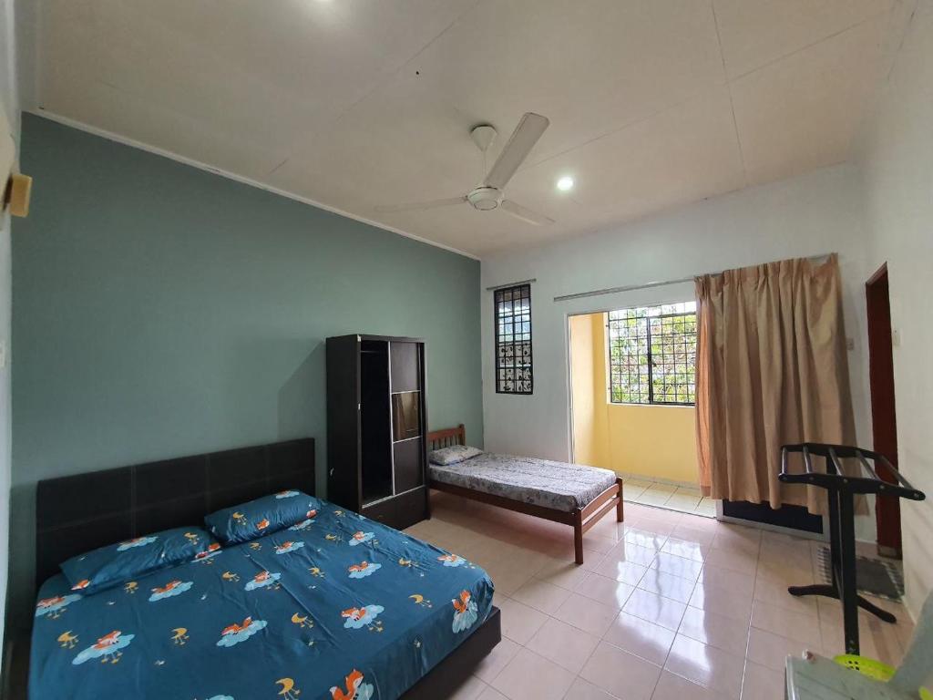 a bedroom with a bed and a bench in it at Homestay DeUmmah House in Cukai