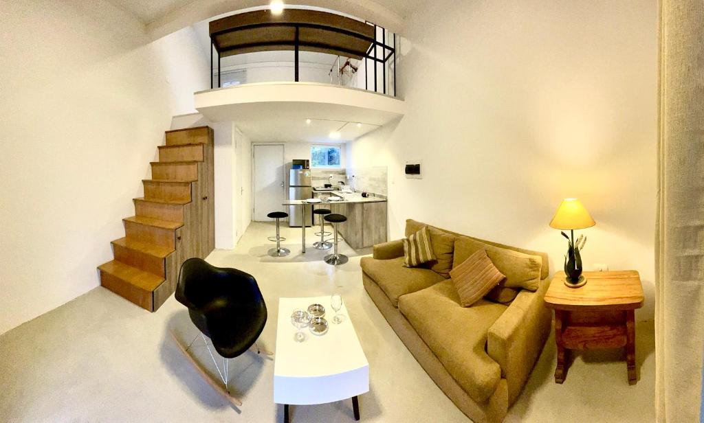 sala de estar con sofá y escalera en Tiny Houses en Asunción. Zona Aeropuerto-Rakiura en Zarate Isla
