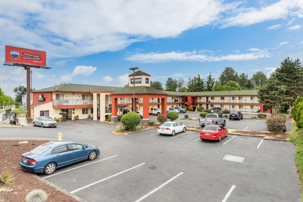 a hotel with cars parked in a parking lot at Days Inn by Wyndham Federal Way in Federal Way