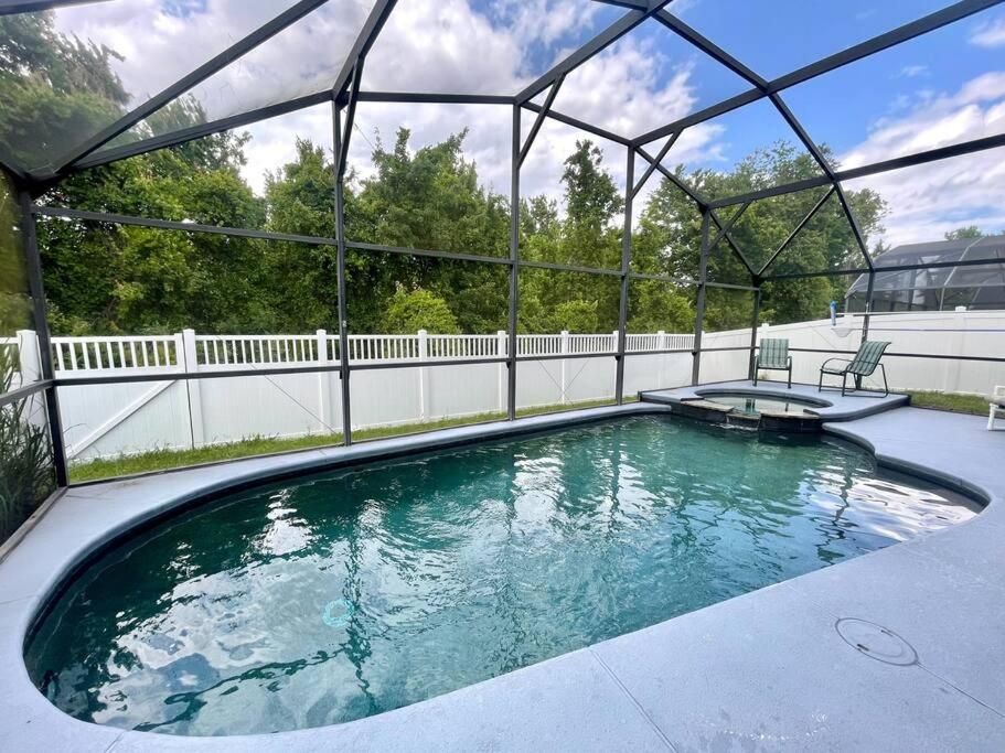 una gran piscina con una valla blanca en Luxury Disney Family Villa (5-Bedroom, pool & spa) en Kissimmee