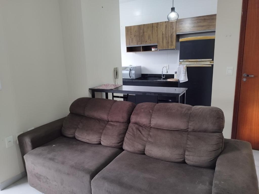 ein braunes Sofa im Wohnzimmer mit Küche in der Unterkunft Apartamento com garagem e perto das praias. in Palhoça