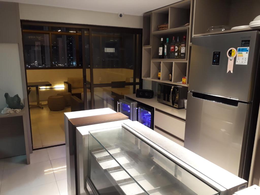 a kitchen with a refrigerator and a glass case at Maravilhoso Apt 109 Home Service próximo Shopping Partage e Rodoviária in Campina Grande
