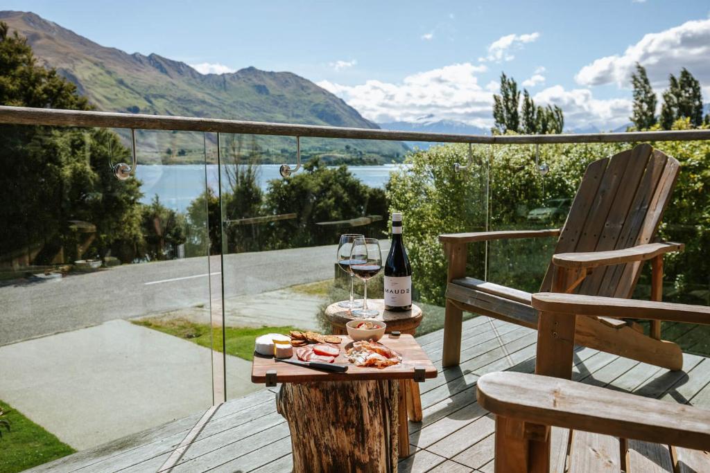 a bottle of wine on a table on a deck at Lakeside Road - Sleeps 8 - Lake Views - Lake Front in Wanaka