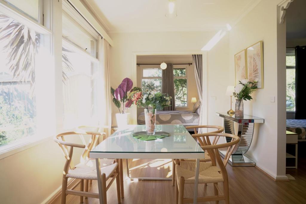 comedor con mesa de cristal y sillas en Family home in Prime location Melbourne, en Fern Tree Gully