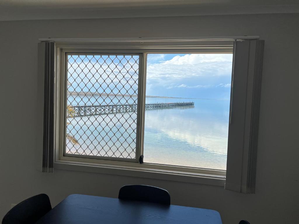 una ventana en una habitación con vistas al océano en Beachside & Jetty View Apartment 7 - Sea Eagle Nest Apartment, en Streaky Bay