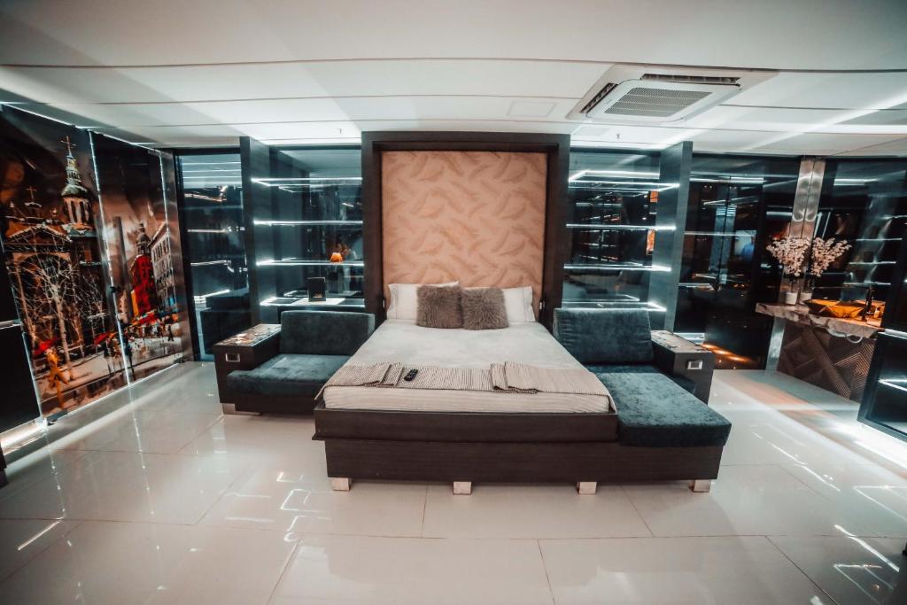 Un dormitorio con una cama, un sofá y una silla. en 1Million Luxury Suites, en Medellín