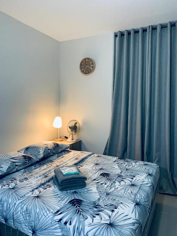 1 dormitorio con 1 cama con cortinas azules en Angel's Nest, en Lo-oc