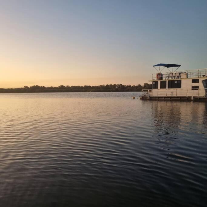 a boat docked at a dock on a lake at The one & only Houseboat Hire on Maroochy River in Maroochydore
