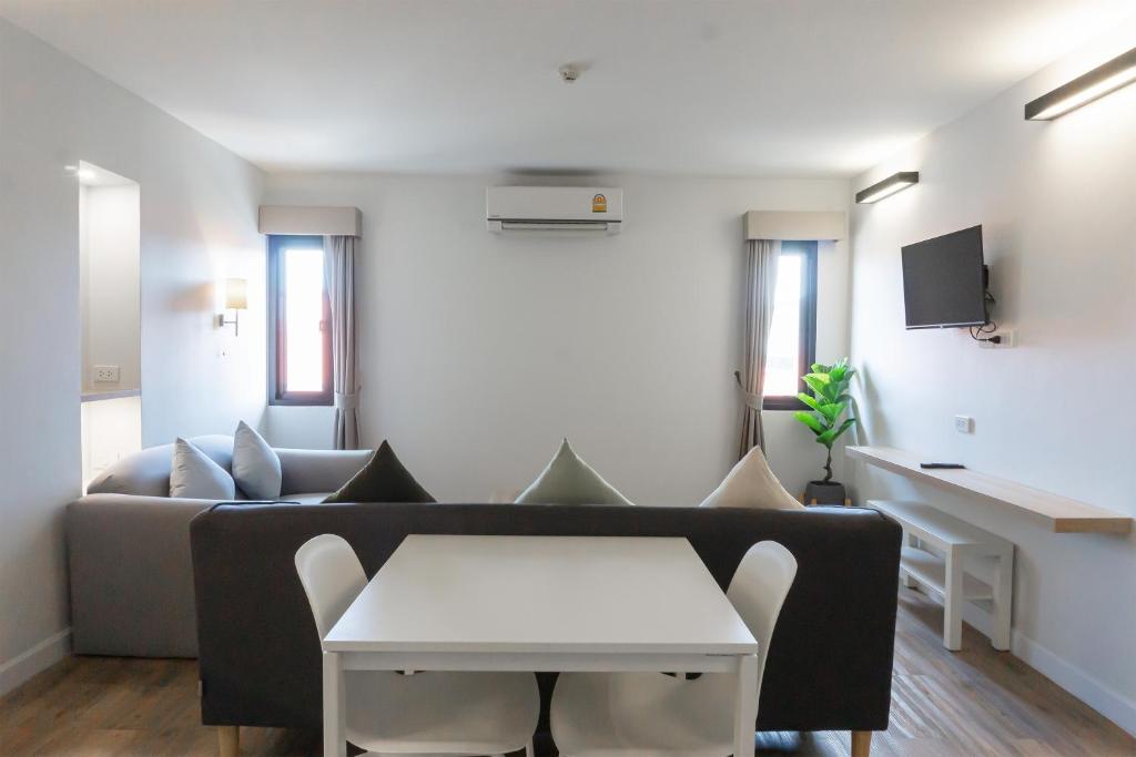 uma sala de estar com um sofá e uma mesa em Carnation Residence em Samut Prakan