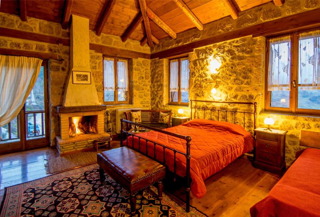 1 dormitorio con 1 cama y chimenea en Pigi Tarlampa Hotel en Ano Trikala