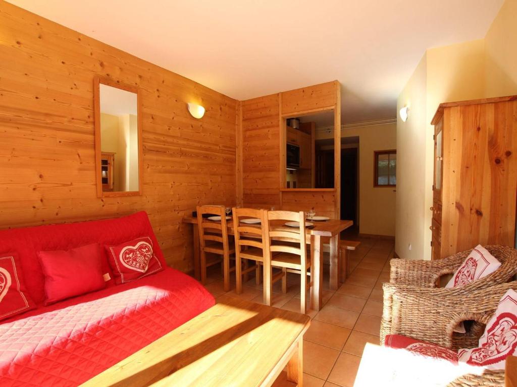un salon avec un canapé rouge et une table dans l'établissement Charmant T2 avec coin montagne, proche pistes et commerces, 6 couchages, terrasse, Serre Chevalier - FR-1-330E-104, à Saint-Chaffrey