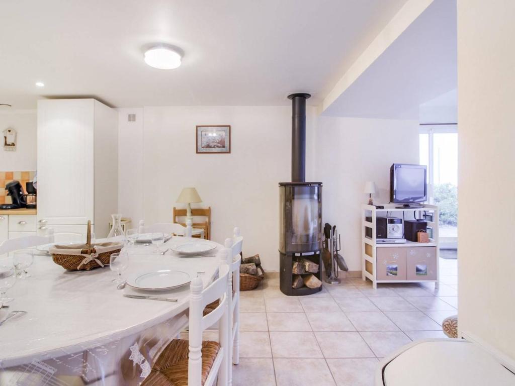 a dining room with a table and a fireplace at Maison Betpouey, 5 pièces, 8 personnes - FR-1-402-83 in Betpouey