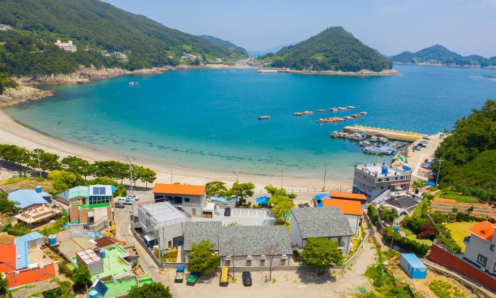 een luchtzicht op een strand met boten in het water bij Seolli Resort Pension in Namhae