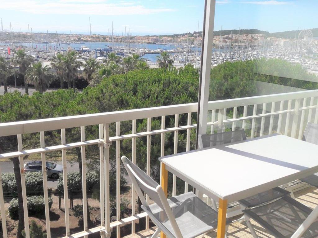 einen Balkon mit einem Tisch und Stühlen sowie Hafenblick in der Unterkunft Studio Cap d'Agde, 1 pièce, 4 personnes - FR-1-607-71 in Cap d'Agde