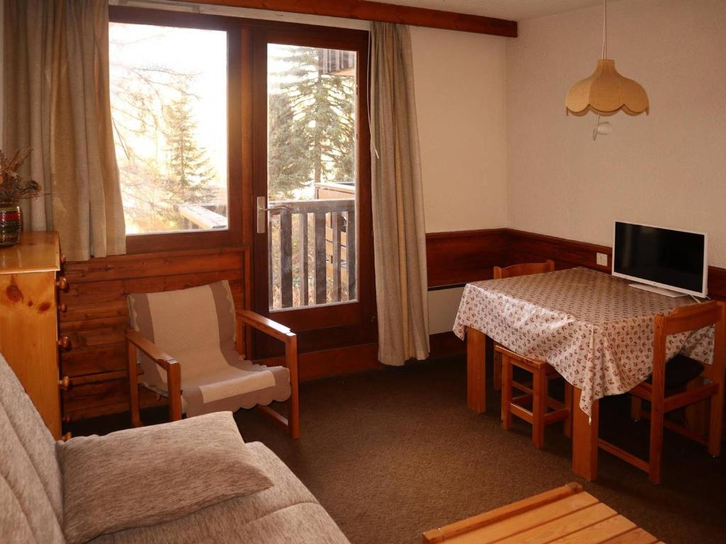 - un salon avec une table, un canapé et une fenêtre dans l'établissement Studio Cosy pour 2 avec Balcon et Prestations de Qualité en Cœur de Station - FR-1-322-503, aux Orres