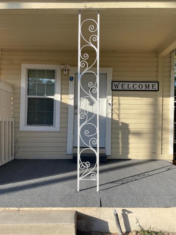 una puerta a una casa con un cartel de bienvenida en Downtown Heaven, en San Antonio