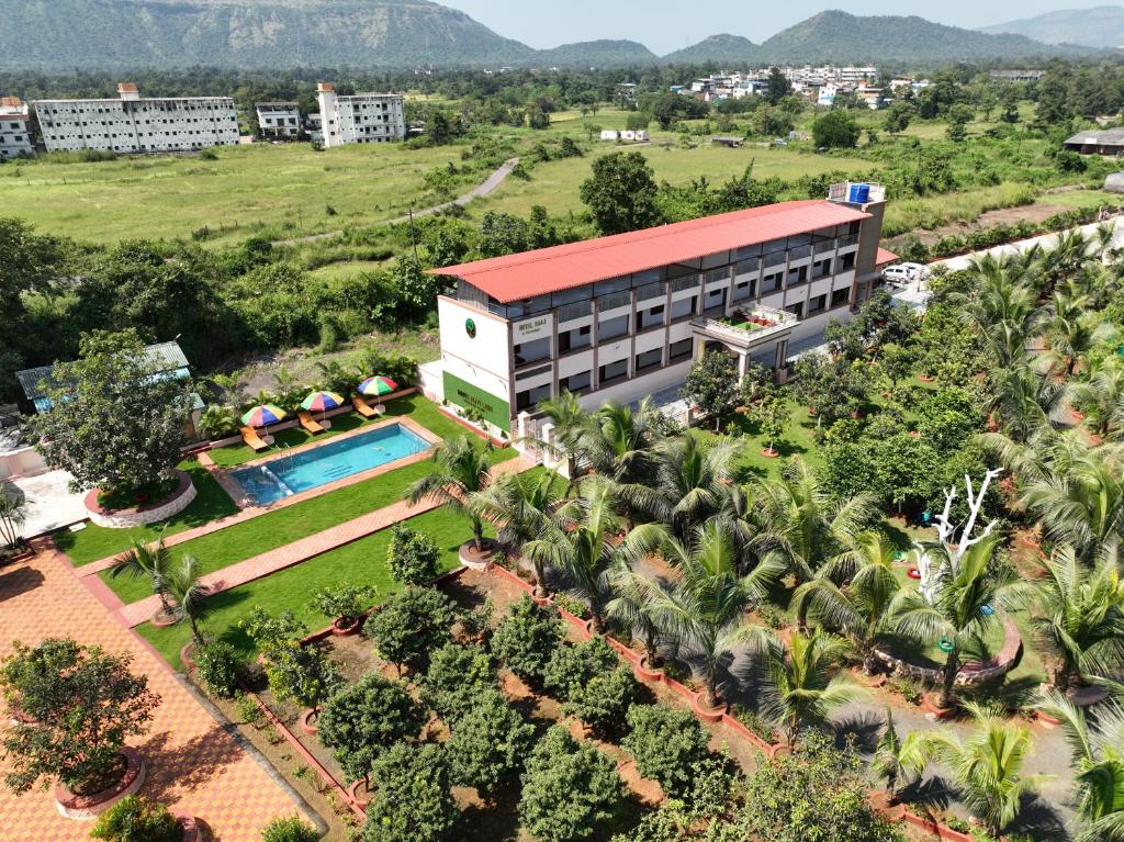een luchtzicht op een hotel met een zwembad en palmbomen bij Raaj Resort in Panvel