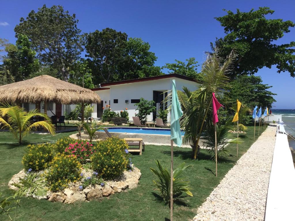 uma villa com piscina e um resort em BambooBeachVilla2 AC NEW OCEANFRONT POOL sunsetview garden kitchen SATELLITE STARLINK WI-FI em Dimiao