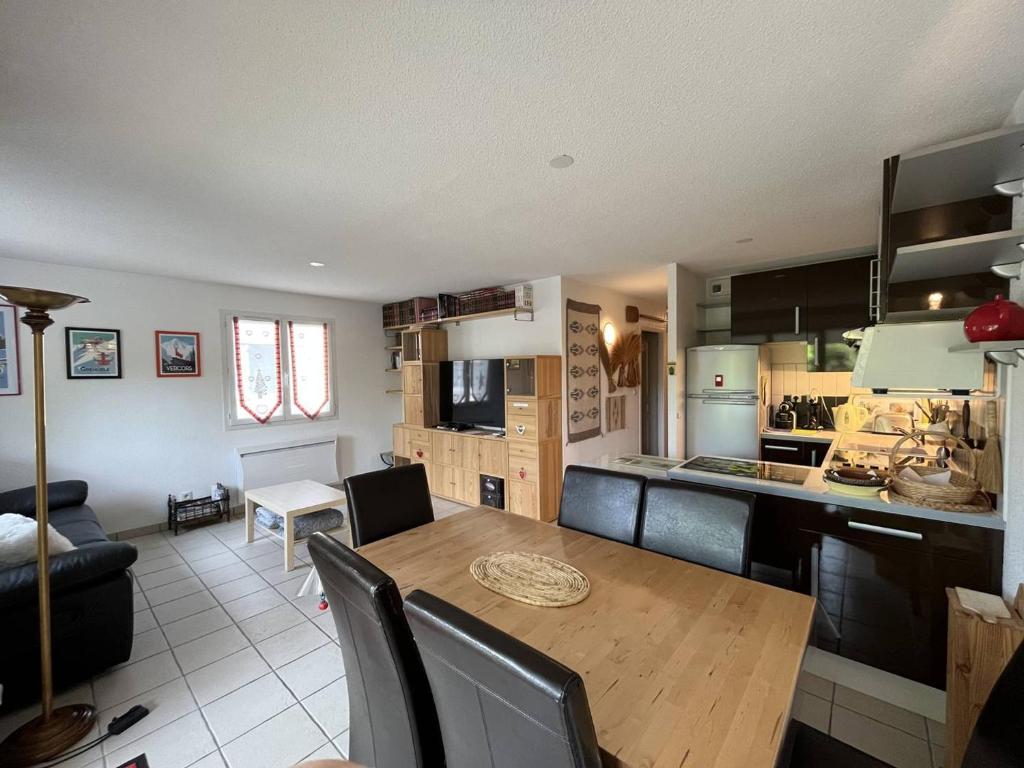 a kitchen and dining room with a wooden table and chairs at Appartement Villard-de-Lans, 3 pièces, 4 personnes - FR-1-548-24 in Villard-de-Lans