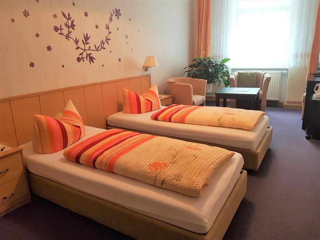 a room with two beds with pillows on them at Pension Zur Altdeutschen in Zschopau