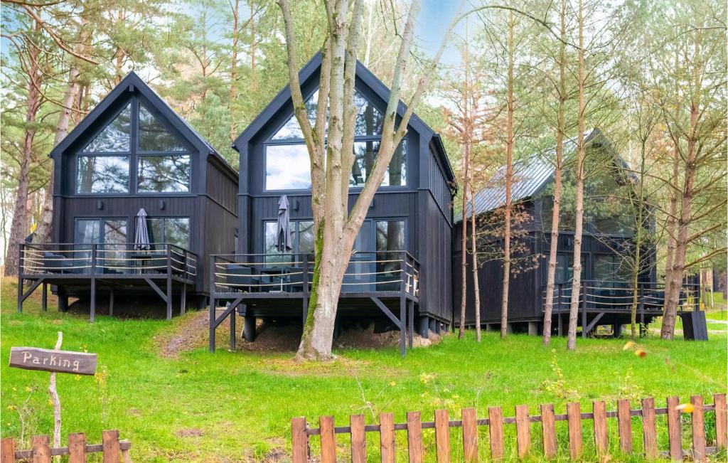 a black house in the middle of the forest at Nice Home In Frombork With Outdoor Swimming Pool, Wifi And 1 Bedrooms in Frombork