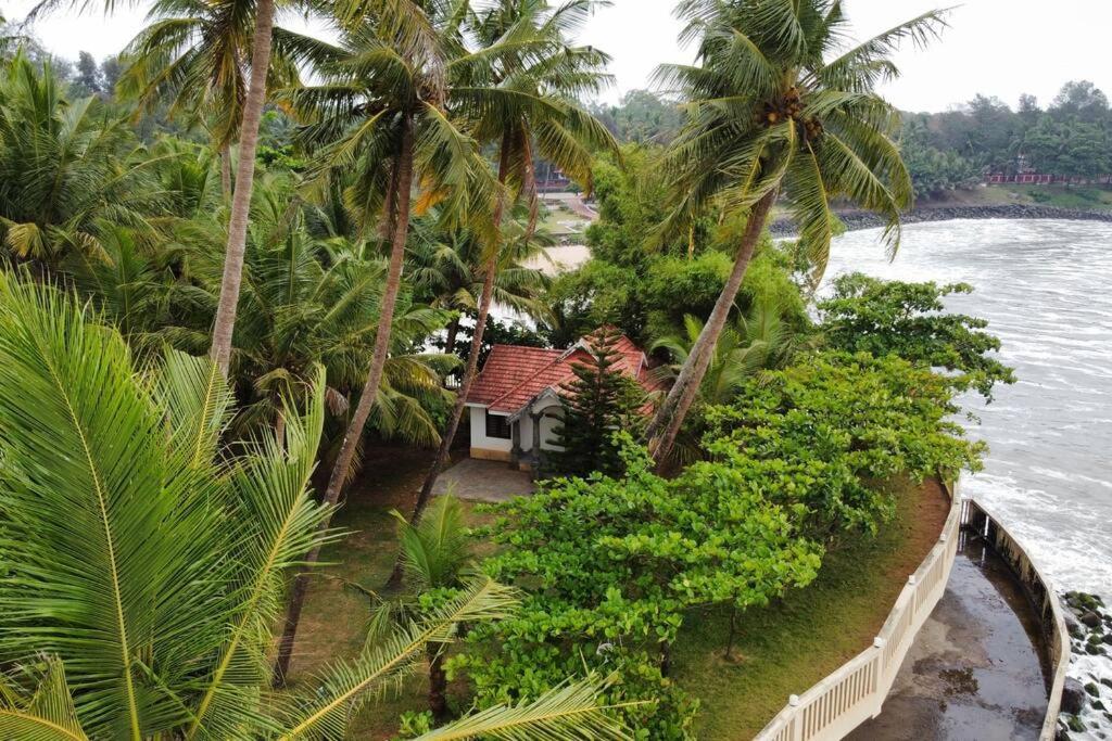 an aerial view of a resort with palm trees at Willo Stays Sea View Home Kannur Landsend in Kannur