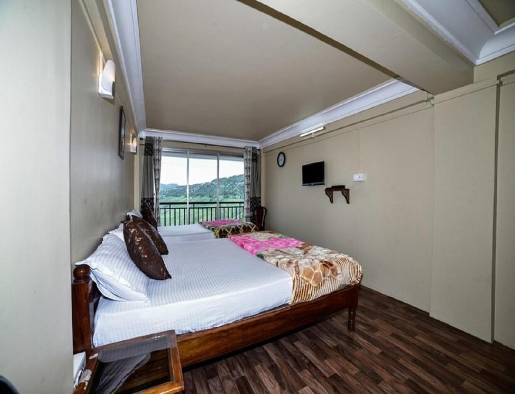 um quarto com uma cama num quarto com uma janela em Ghangri Sherpa Luxury Homestay, Darjiling em Sonāda