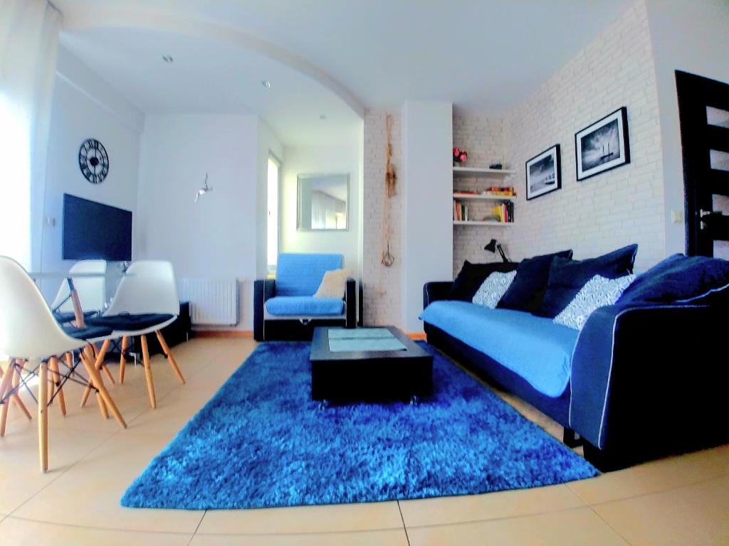 a living room with a blue couch and a blue rug at Apartament Wyspa, 2 pokoje, parking gratis in Międzywodzie