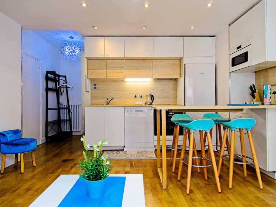 a kitchen with white cabinets and blue bar stools at Loft 4/6 pers proximité centre ville, gare et tram in Caen