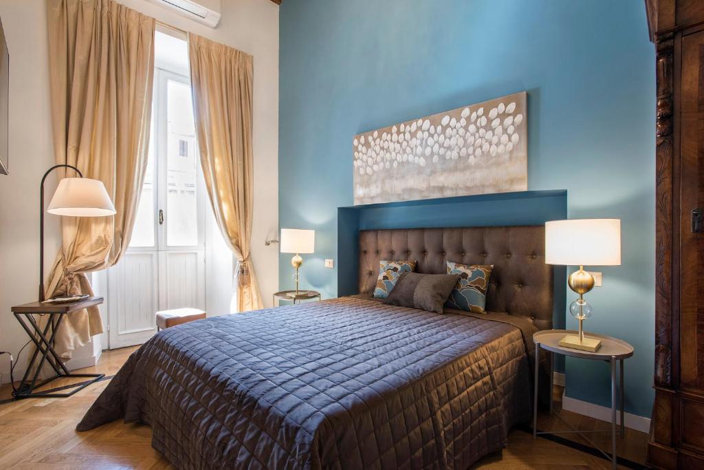 a bedroom with a large bed with a blue wall at Casa Ameliotta Design in Rome