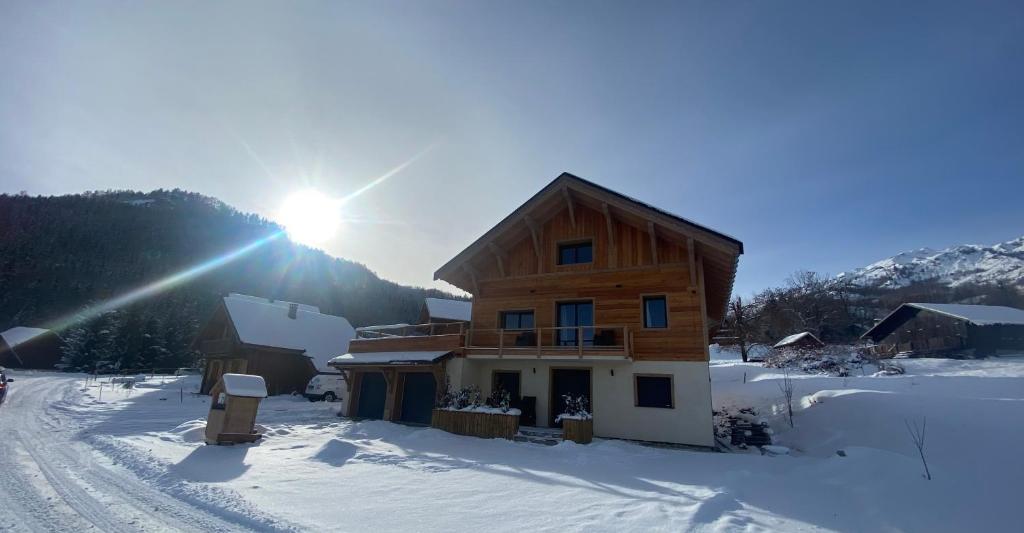 a wooden house in the snow with the sun shining at Bottières in Saint-Pancrace