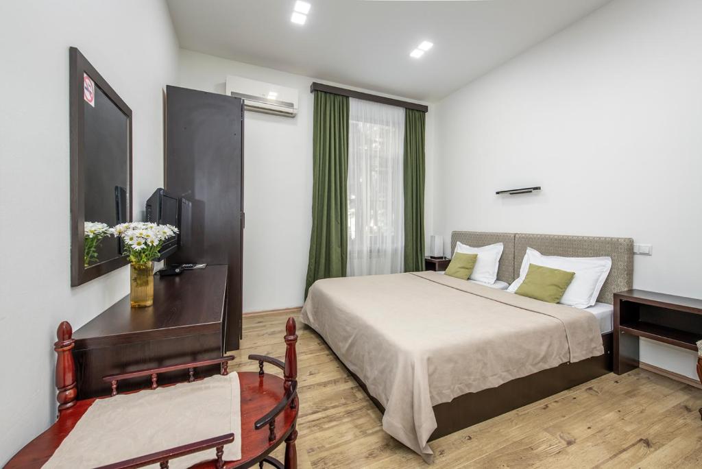 1 dormitorio con cama, mesa y escritorio en Apart Hotel GH, en Tiflis