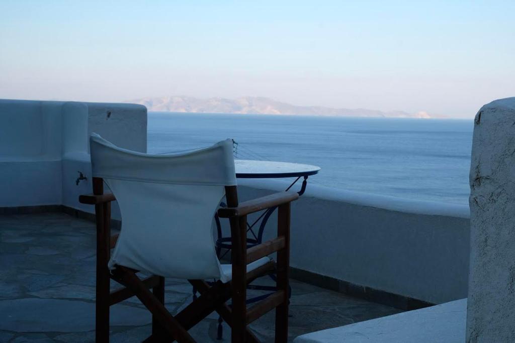 a table and chair sitting on a balcony overlooking the ocean at Beach House in Tinos island in Kardiani