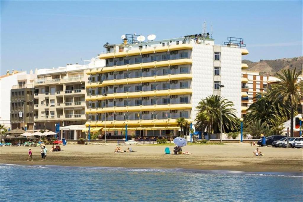 um hotel na praia com pessoas na praia em Rincón Sol em Rincón de la Victoria