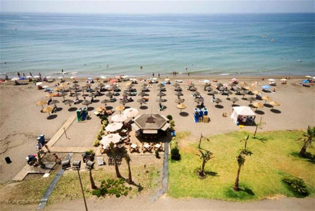 a group of umbrellas on a beach with the ocean at Rincón Sol in Rincón de la Victoria