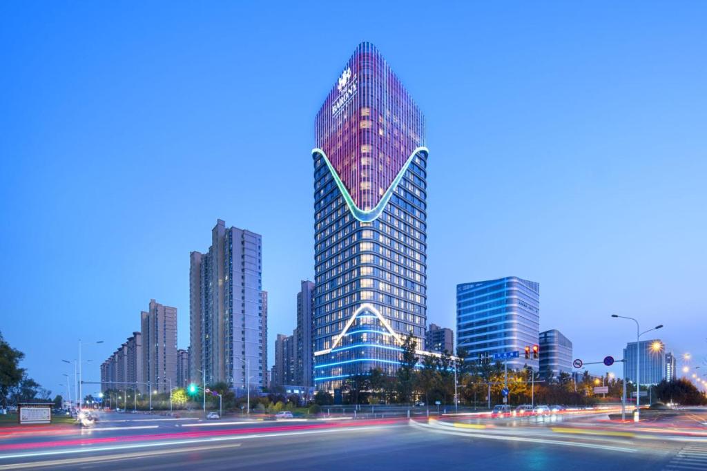 un gratte-ciel haut dans une ville la nuit dans l'établissement The Barony Jinan East, à Jinan