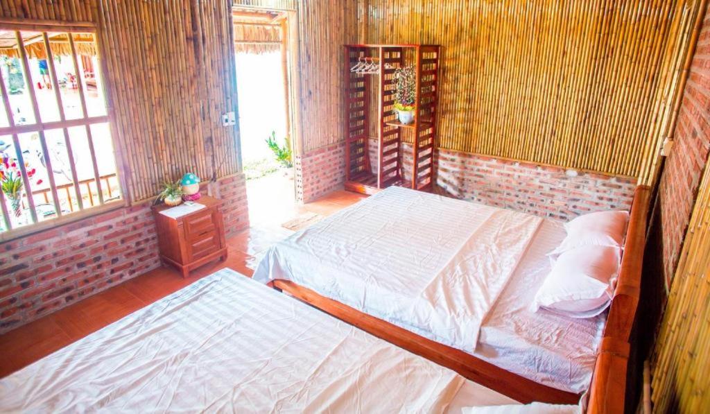 a bedroom with two beds and a window at Ninh Binh Bungalow Homestay in Ninh Binh